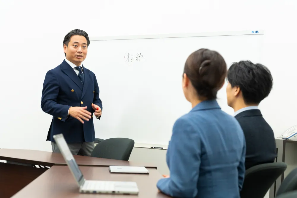 ホワイトボードの前で研修をする先輩社員